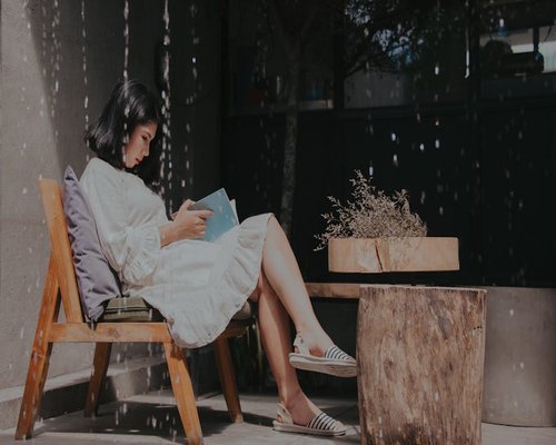 Relaxed woman enjoying reading outdoors with natural light